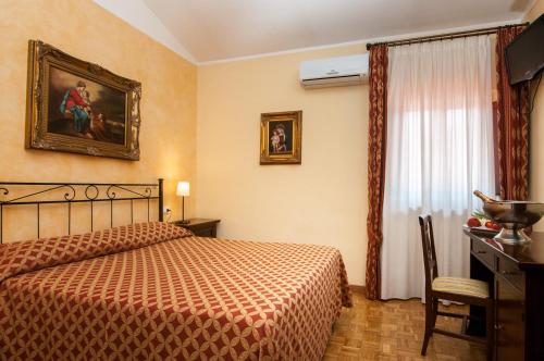 a bedroom with a bed and a dresser and a window at La Vecchia Fattoria in Loreto