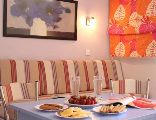 a table with two plates of food on it at Amaryllis Hotel Apartments in Tolo