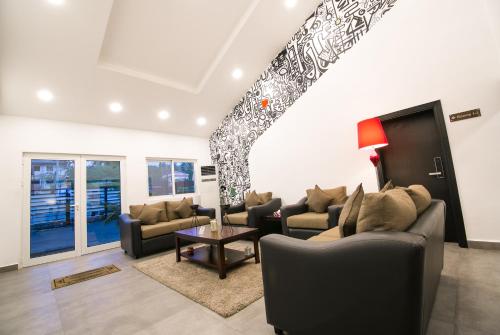 a living room with two couches and a staircase at Sinclair Guest House in Abuja