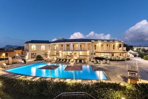 einen Blick auf ein Herrenhaus mit einem Pool in der Unterkunft Terradimare Resort&Spa in San Teodoro