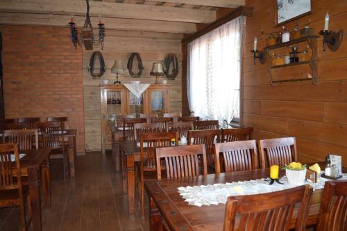 a dining room with wooden tables and chairs at OBERŻA in Borsuki