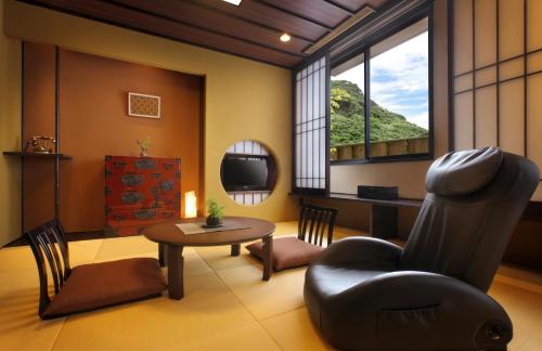 a living room with a chair and a table at 旅館かわな -Ryokan Kawana- in Kimitsu