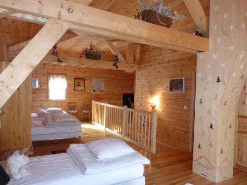 une chambre avec deux lits dans une cabane en rondins dans l'établissement Chalet Le Villard, à Enchastrayes