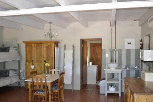 eine Küche und ein Esszimmer mit einem Tisch und Stühlen in der Unterkunft Rooiheuwel Cottage in Wellington