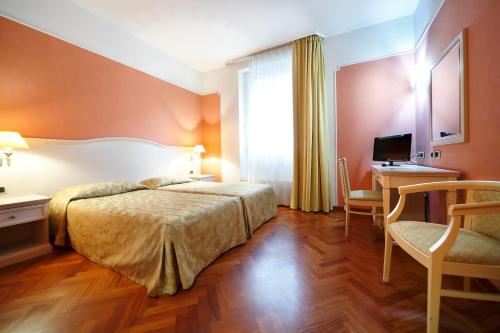 a hotel room with a bed and a desk at Hotel Terminal in Milan