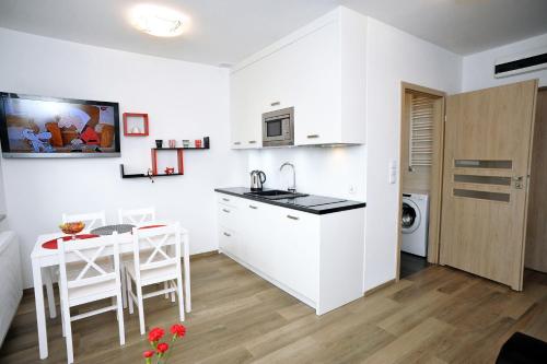 a kitchen and dining room with a table and a sink at Dream Apartment in Świnoujście