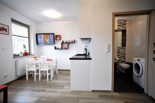 a kitchen and living room with a sink and a table at Dream Apartment in Świnoujście