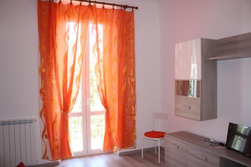 Habitación con ventana con cortina naranja en Cà de Maòa un tuffo nel mare, en La Spezia