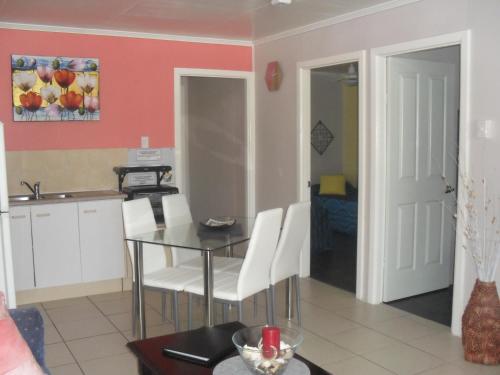 a kitchen and dining room with a table and chairs at Beachlander Self-Contained Holiday Apartments in Coffs Harbour