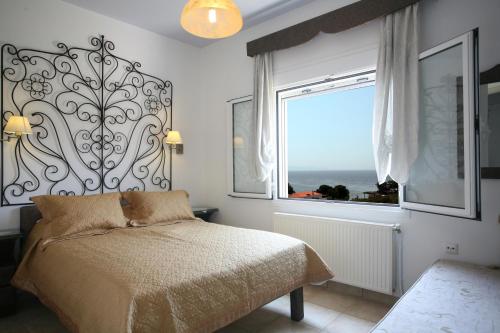 ein Schlafzimmer mit einem Bett und einem großen Fenster in der Unterkunft Aigli Apartments in Nea Anchialos