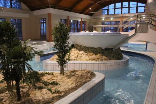 una gran piscina con bañera en un edificio en Fenyő Panzió, en Mezőkövesd