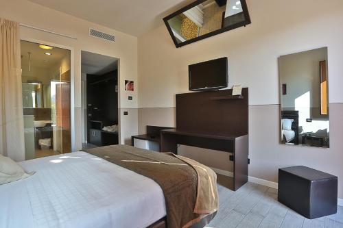 una camera con letto, scrivania e TV di Rimmel Motel a Parma
