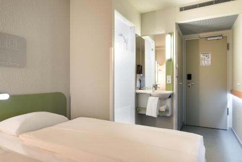 a kitchen with a white refrigerator and a white sink at Ibis Budget Leipzig City in Leipzig