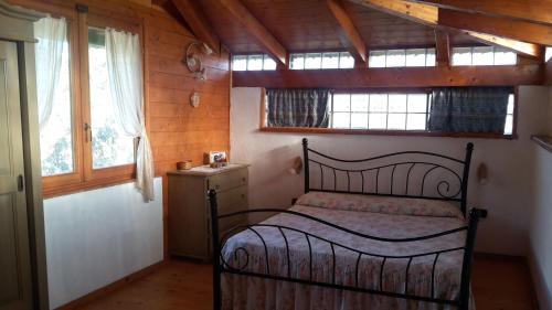una camera da letto con un letto in una stanza con finestre di Casa Vacanze Paola a Quartu SantʼElena
