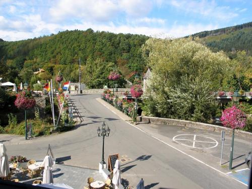 an empty street in a town with trees and a mountain at Le Baron Apartments in Stavelot