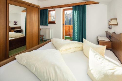 a bedroom with a bed and a mirror at Haus am Mühlanger in Serfaus