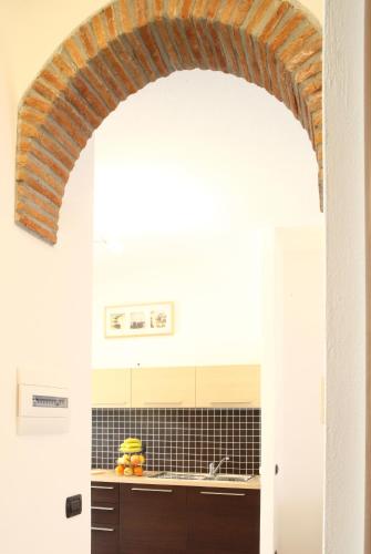 a kitchen with a brick archway over a sink at Appartamenti In Piazzetta in Deiva Marina