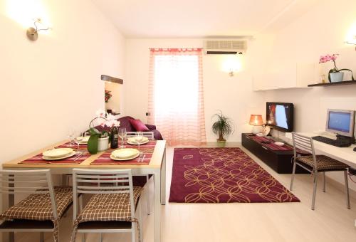 una cucina e un soggiorno con tavolo e sedie di Appartamenti In Piazzetta a Deiva Marina