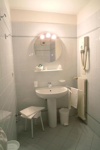 a white bathroom with a sink and a mirror at Albergo Sapori in Tolè