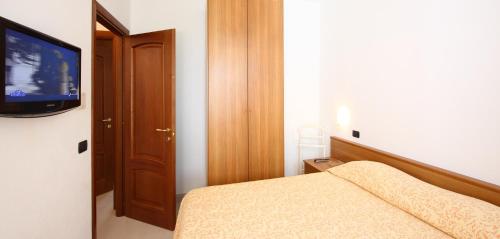 a bedroom with a bed and a flat screen tv at Appartamenti In Piazzetta in Deiva Marina