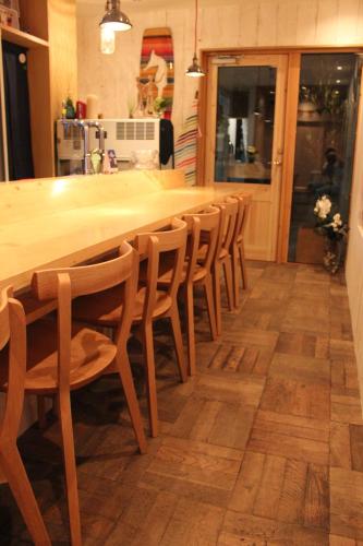 a kitchen with a long wooden table and chairs at guesthouse SHIBAFU in Kamakura