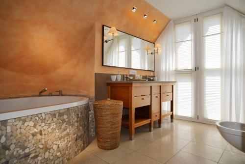 a bathroom with a tub and a sink and a mirror at Hotel Die Sonne Frankenberg in Frankenberg