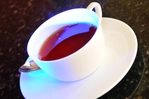 a cup of coffee on a plate with a spoon at Balmoral Guest House in Darlington