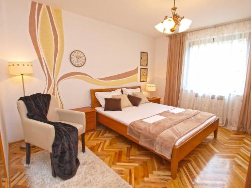 um quarto com uma cama e uma cadeira em Apartments Prostin 772 em Fažana