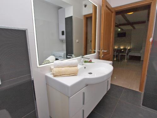 uma casa de banho com um lavatório branco e um espelho. em Apartments Prostin 772 em Fažana