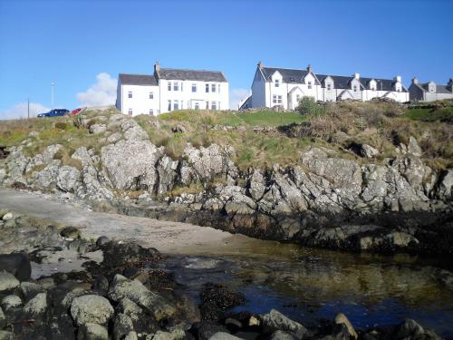 eine Gruppe von Häusern auf einem felsigen Hügel in der Unterkunft Burnside Lodge in Portnahaven