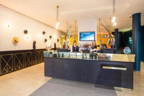 two people sitting at a counter in a salon at Hotel Gatsby by HappyCulture in Chassieu