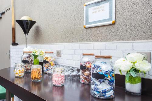 a table with many jars and flowers on it at Hotel Gatsby by HappyCulture in Chassieu