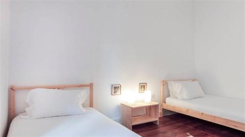 リスボンにあるSpacious Tailor Made Bairro Altoのベッド2台、テーブル(ランプ付)が備わる客室です。