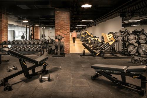 a gym with rows of dumbbells and a man walking down a hallway at Lionel Hotel Istanbul in Istanbul