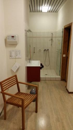 uma casa de banho com um banco, um chuveiro e um lavatório. em Ferienwohnung "Casa Annabella" em Ascona