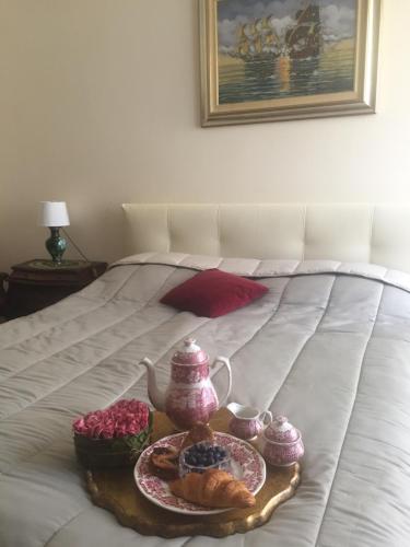 ラパッロにあるCasa Cristinaのベッドの上にティーポットとペストリーを用意したトレイ