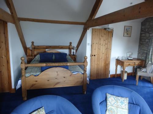 een slaapkamer met een houten bed in een kamer bij Claremont House in Saundersfoot