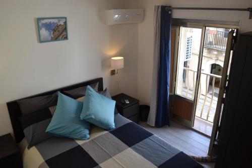 キアラモンテ・グルフィにあるAkrillhouse Locazione Turisticaのベッドルーム1室(青い枕のベッド1台、窓付)