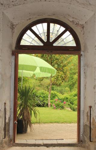an open door with a green umbrella in a yard at il molinaccio al rio chiaro in Civitella dʼAgliano