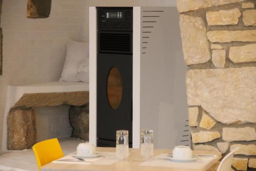 a room with a table and a wall with a microwave at Hôtel Le Sainte Florence in Sainte-Florence