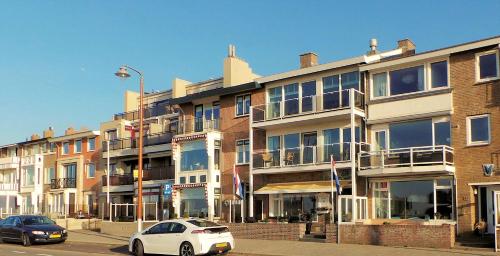 a white car parked in front of a building at Hotel B&B Seahorse in Katwijk