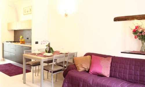 a living room with a purple couch and a table at Appartamenti In Piazzetta in Deiva Marina