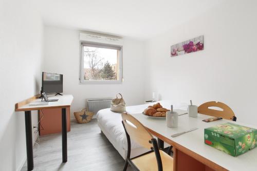 a room with a desk and a bed with a computer at Neoresid - R&eacute;sidence Clos Morlot in Dijon