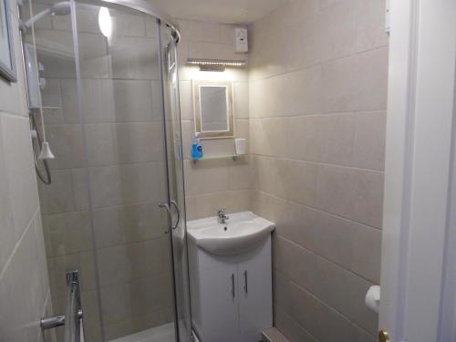 a bathroom with a toilet and a sink and a shower at Langdon Farm Cottage in Boyton