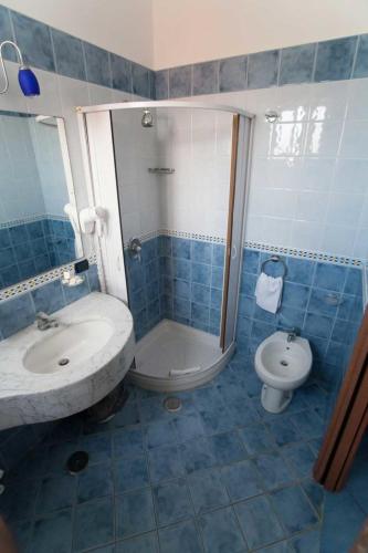 a blue tiled bathroom with a sink and a toilet at Hotel Klein Wien in Piano di Sorrento