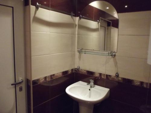 W łazience znajduje się umywalka i lustro. w obiekcie House for Guests and Friends w mieście Swisztow