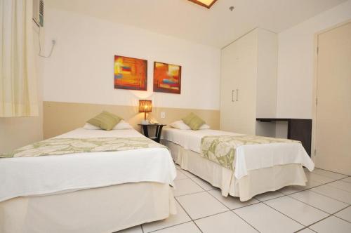 two beds in a room with white walls at ApartHotel no Gran Solare Lençois Barreirinhas in Barreirinhas