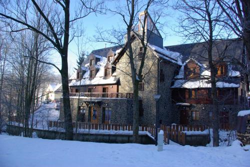 a large house with a fence in the snow at Penzion Ovečka in Nýdek