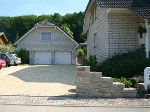 a house with two garage doors and a driveway at Ferienhaus Waldperle Harzblick in Wernrode
