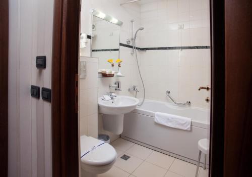 a bathroom with a sink and a toilet and a bath tub at Hotel Otrada in Odesa